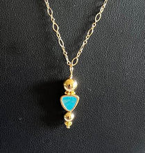 Natural turquoise drop surrounded by 14 karat gold filled balls. The pendant measures 1 3/8 inches long by 7/8 inches wide. The chain is 18 inches long.