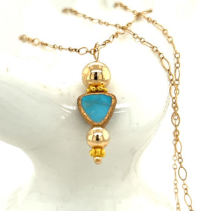 Natural turquoise drop pendant surrounded by rich gold balls. 14 karat gold filled chain measuring 18 inches. Pendant is 7/8 inches wide by  1 3/8 inches long.