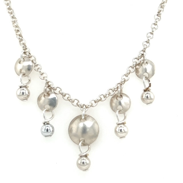 Sterling silver necklace with hand cut, formed, filed circular cups with a small silver ball drop. Measuring 18 1/2 inches in length.