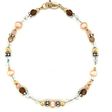 Peachy pink freshwater pearl,silver and gold accents with earth tone and sparkly clear crystals. A vailable in four sizes 7, 7 1/4, 7 1/2, and 8 inches. if you need another size please me know.