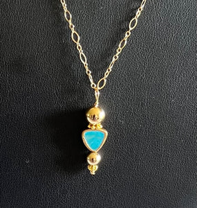 Natural turquoise drop surrounded by 14 karat gold filled balls. The pendant measures 1 3/8 inches long by 7/8 inches wide. The chain is 18 inches long.